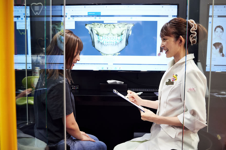 ヘッドレストとチンレストで前後方向から固定座位による歯科用 CT 撮影の様子