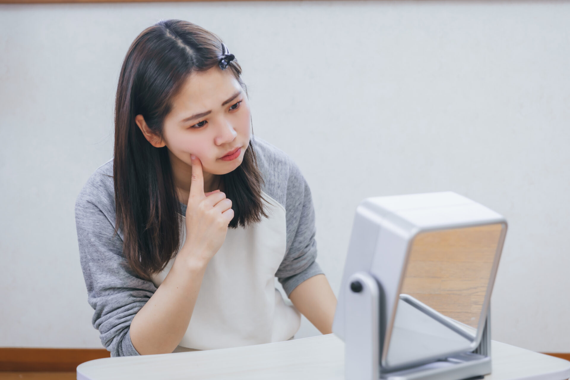 深刻な表情で鏡を覗き込む女性