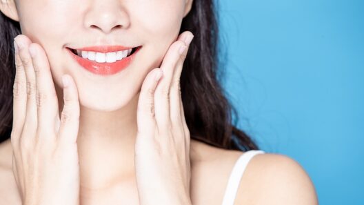 頬に手を当てて微笑む女性。